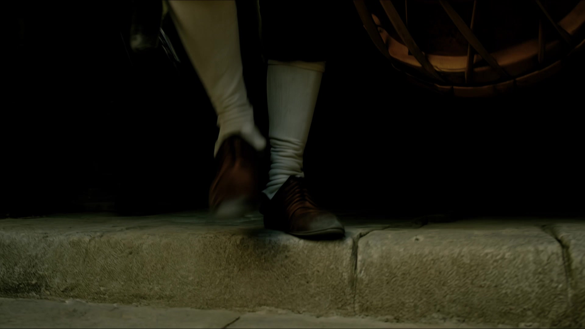 A character steps into a dark stone setting