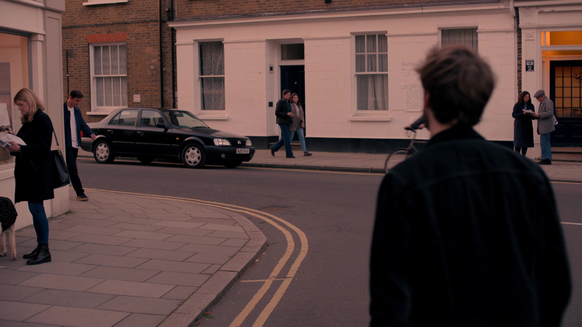 Two friends meet on a street at dusk